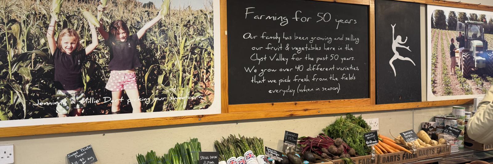 display of vegetables with farm signage for Dart's Farm in the background