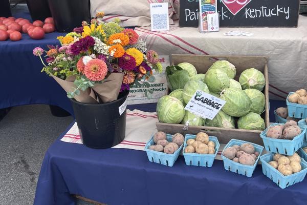 produce and flowers on table with prices