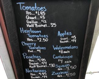 a sign with prices for a variety of produce items