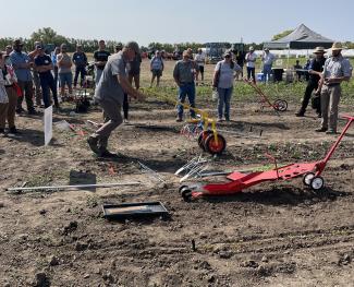 man pushing a small cultivation implement