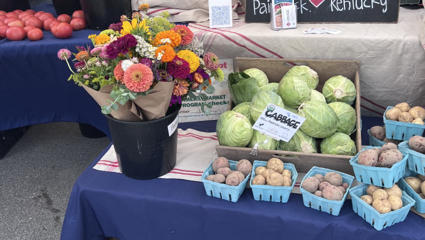 produce and flowers on table with prices