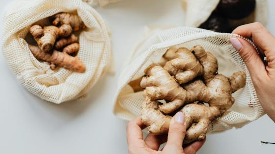 ginger and turmeric in cloth bags with hands holding them