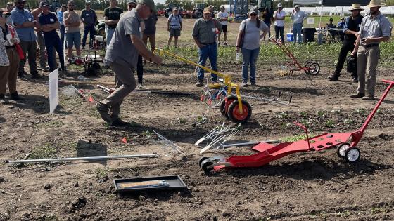 man pushing a small cultivation implement