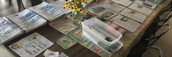 table covered with publications and sign up sheets